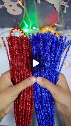 two hands holding red and blue tinsel wrapped straws