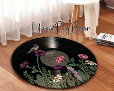 a vinyl record with flowers and birds on it sitting on the floor next to a book