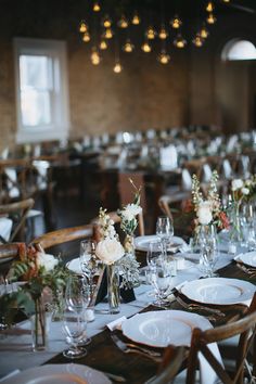 the tables are set with white plates and silverware