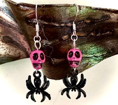 pink and black skull earrings with spider legs