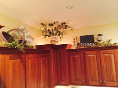 a kitchen with wooden cabinets and plants on top