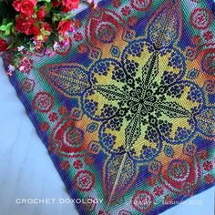 a close up of a table cloth with flowers in the background and a potted plant next to it