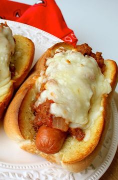 two hot dogs covered in cheese on a plate