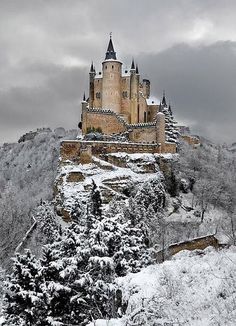 a castle on top of a mountain covered in snow