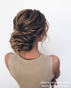 a woman with her back to the camera, braided into a low bun hairstyle