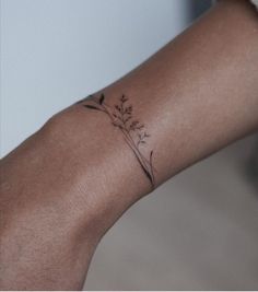 a woman's arm with a small flower tattoo on it