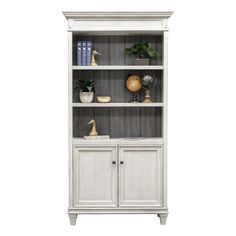 a white bookcase with two doors and some plants on top of the bookshelf