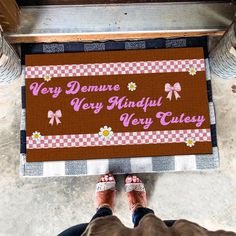 a person standing in front of a door mat that says very famous very curly celesy