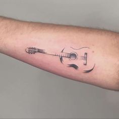 a man's arm with a guitar tattoo on it