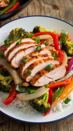 a white plate topped with meat and veggies on top of rice covered in sauce