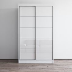 an empty room with white furniture and wood flooring