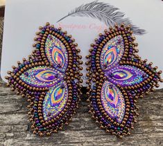 I love these earrings! They remind me of New Orleans and have a Mardi Gras feel to them They are done with a multi colour iris/peacock mix seed bead to set off the peacock blue purple gems, soft Italian leather backing. They measure 1 1/2" inches wide and almost 2 1/2"inches long. These will sparkle and shine in natural or artificial light  I am Cree First Nation so you are buying authentic items made by myself. Mardi Gras Earrings, Earrings Native American, Purple Gems, Earrings Purple, Purple Earrings