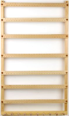 a wooden shelf with several pegs on the bottom and two rows of shelves below