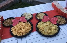 three mickey and minnie mouse plates filled with snacks