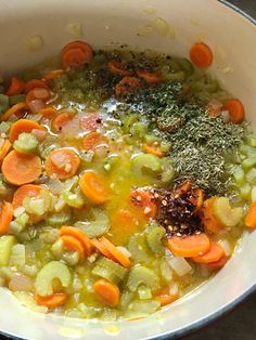 a pot full of soup with carrots, celery and broccoli