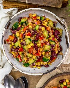 a bowl filled with beans and vegetables next to two bowls full of other food items