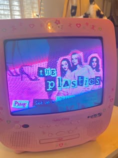 an old tv sitting on top of a table with the word plastics written on it