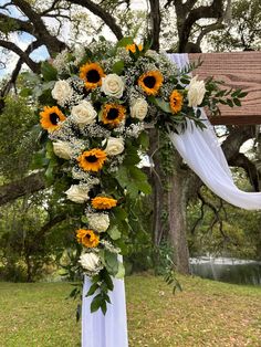 a cross decorated with sunflowers and greenery