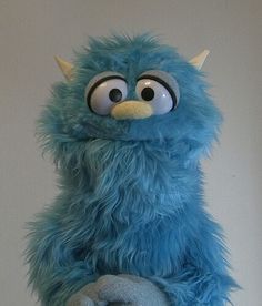 a blue stuffed animal sitting on top of a table