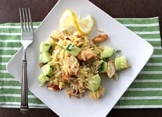 a white plate topped with pasta and veggies next to a knife and fork