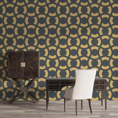 a chair and table in front of a wall with an intricate pattern on it,