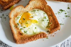 an egg in a heart shaped toast on a plate