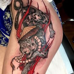 a woman with a tattoo on her thigh has an image of a cat and umbrella