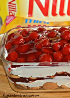 a dessert dish with cherries and whipped cream in the center on a wooden table