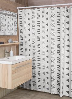 a bathroom with a sink, mirror and shower curtain