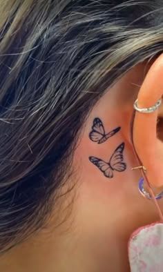 a woman's ear with three butterflies on it