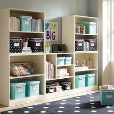 a room filled with lots of different types of bookshelves and bins on top of each shelf