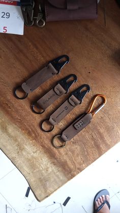 four pairs of scissors sitting on top of a wooden table next to a pair of sandals