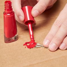 a person is painting something red on the table