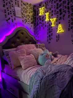 a bed room with a neatly made bed and neon lights on the wall above it