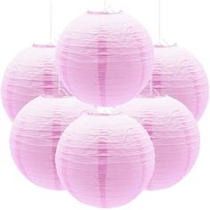 four pink paper lanterns hanging from strings on a white background, set of five in the shape of round balls