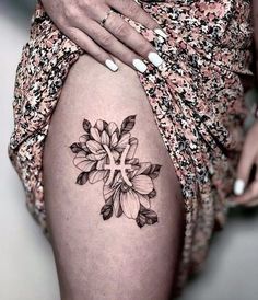 a woman's thigh with a flower tattoo on the lower part of her leg