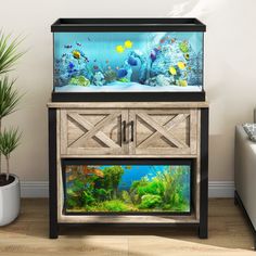 an aquarium with fish and plants in it on top of a wooden cabinet next to a white couch