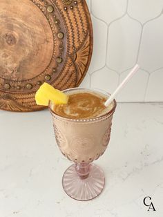 a drink with a yellow wedge in it sitting on a table