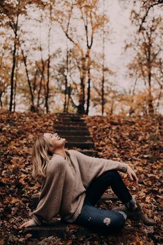 a woman laying on the ground in leaves