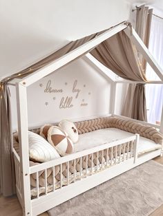 a baby crib in the corner of a room with two pillows on top of it