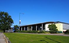 the building has many windows and is next to a grassy area with steps leading up to it