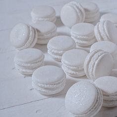 there are many white macaroons on the table