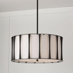 a light fixture hanging from the ceiling in a room with white walls and black trim