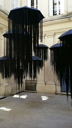 several black umbrellas are hanging in the air