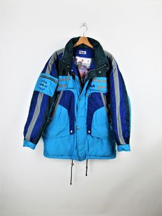 Fila Ski Team Italia vintage 90s padded ski jacket, blue, light blue, green and gray, hood inside the collar, 6 front pockets with zip and 1 on the arm Size XL Measures: Neck/wrist length: 82 cm Length: 83 cm Armpit to armpit width: 67 cm PERFECT - No signs of wear Our garments are all vintage and second-hand. Any signs of wear or defects are documented with photos and description. For any questions, photos, videos we are at your disposal. Blue Nylon Parka For Outdoor Activities, Blue Nylon Outerwear For Winter Sports, Urban Blue Winter Parka, Blue Nylon Windbreaker For Winter Sports, Blue Winter Sports Outerwear, Blue Nylon Windbreaker For Cold Weather, Sporty Blue Parka For Winter, Sporty Blue Winter Parka, Blue Outerwear For Ski Season Outdoor Activities