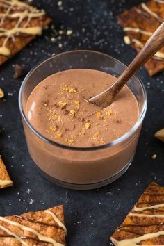 a glass bowl filled with chocolate pudding and topped with caramel drizzle