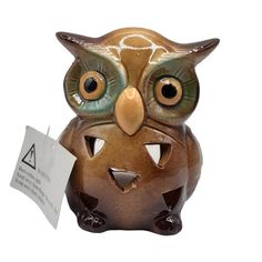 an owl figurine with a tag on it's ear and eyes, sitting in front of a white background