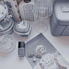 an assortment of jewelry sitting on top of a table next to a bottle of perfume