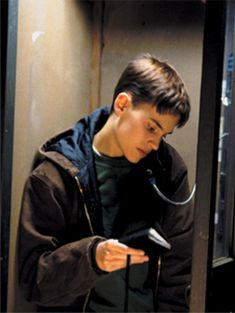 a young man looking at his cell phone while standing in front of a window with a stethoscope