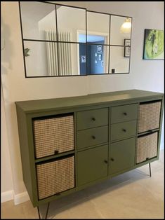 a green dresser with wicker drawers and mirrors